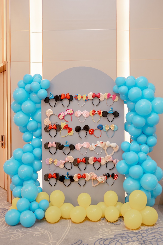 Mickey ear headband display wall with blue and yellow balloons